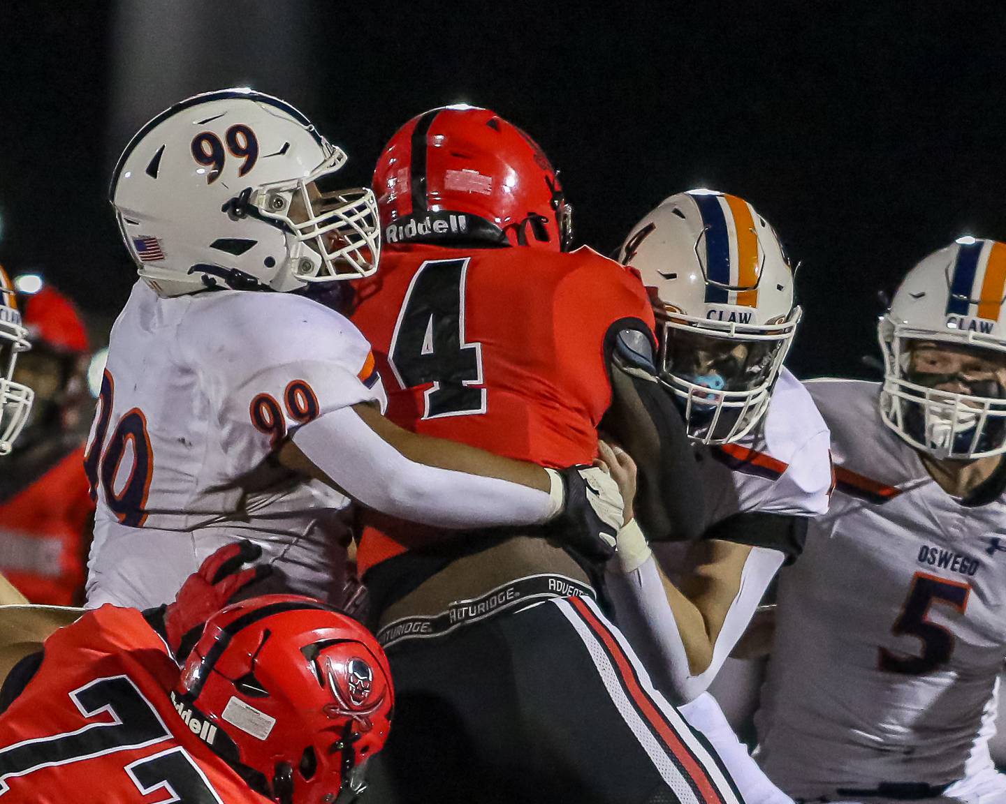 Bolingbrook's Timmie Lewis II (4) is tackled by Oswego's Joshua Flores (99) and Easton Ruby (4) during a football game between Oswego at Bolingbrook on Friday, Oct 4th, 2024  in Bolingbrook.