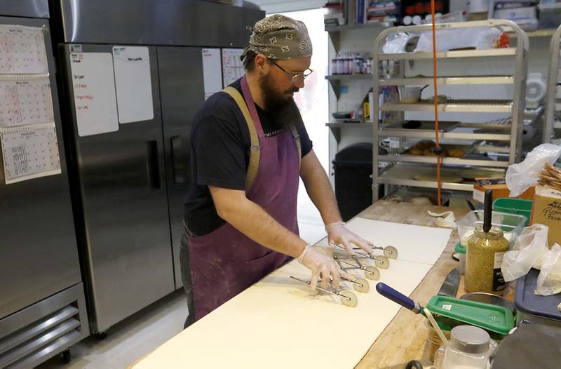 Caleb Hill makes croissants on Friday, March 21, 2025, at Cheshire Cakes, in Crystal Lake.