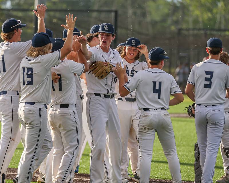 Oswego East's Ryan Johnson (15) celebrates the win with teammates during Class 4A Romeoville Sectional semifinal between Oswego East at Downers Grove North.  May 31, 2023.