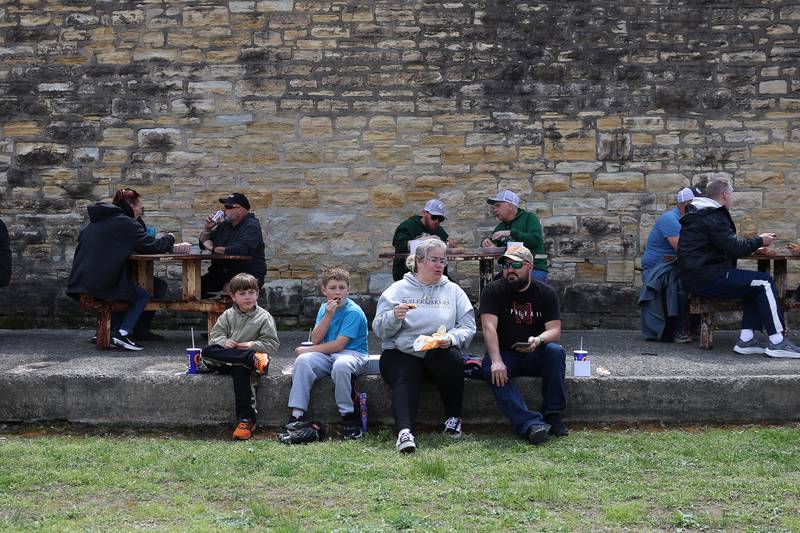 Beau, left to right, Marshall and their mother Leslie Wheeler along with Ben Schuler have lunch in front of a prison building before the Joliet Slammers preseason game at the Old Joliet Prison on Thursday, April 29, 2026 in Joliet.