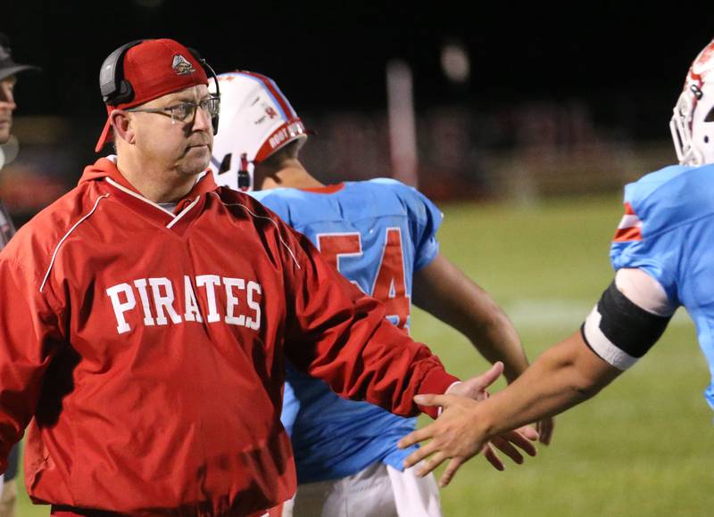 Ottawa football assistant coach Mark Andrews hi-fives players on Friday, Oct. 24, 2025 on Kingman Field at Ottawa High School. Andrews is retiring at the end of the school year.