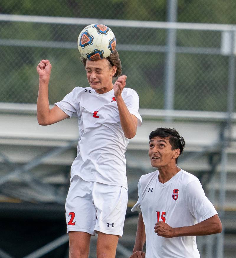Oswego’s Mikey Kroll (2) goes up for a header against Oswego East during a soccer match at Oswego East High School on Monday, Sep 26, 2022.