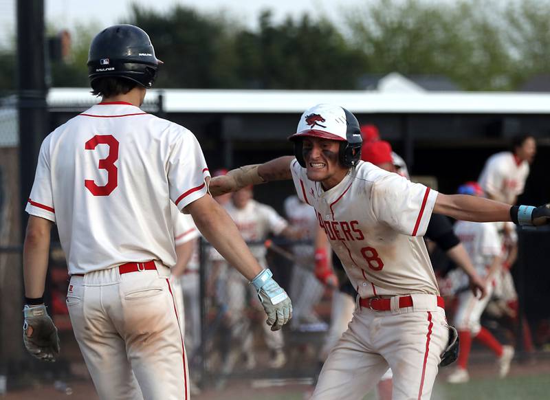 Huntley's Aiden Eickelman (right) celebrates giving Huntley a two run lead after coming home to score in the sixth inning of a Fox Valley Conference baseball game against McHenry on Tuesday, May 8, 2026, at Huntley High School.