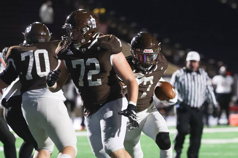 Joliet Catholic’s HJ Grigsby follow the lead block of Jake Jakovich against Leo on Friday, Oct. 6, 2023 in Joliet.