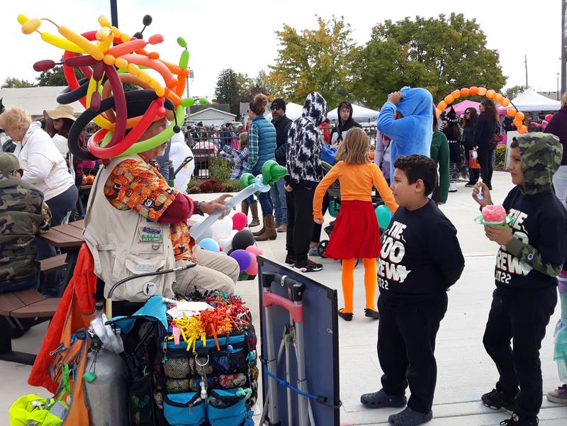 A balloon artist makes inflatables for children to take home Saturday, Oct. 16, 2022, during Oglesby's Harvest Fest at Senica Square.