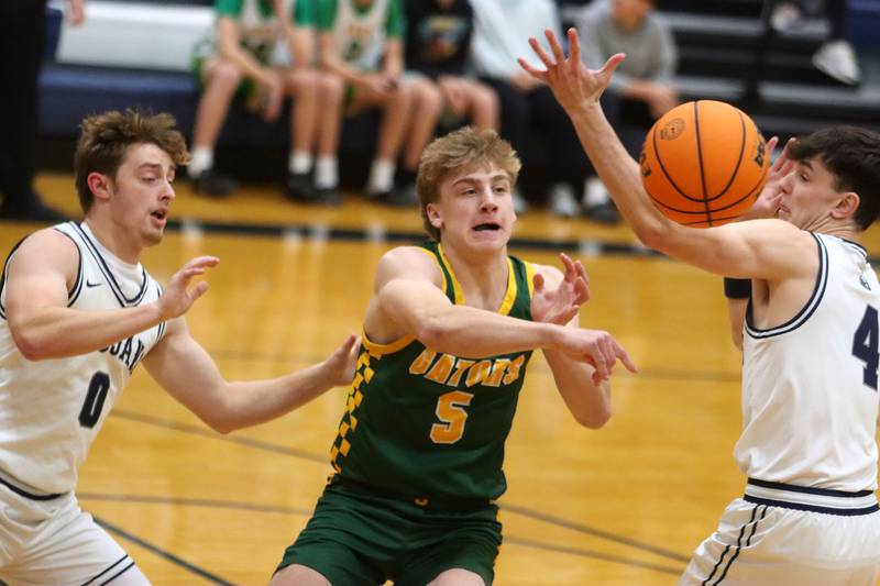 Crystal Lake South’s Carson Trivellini, center, passes between Cary-Grove’s Brandon Freund, left, and Dylan Dumele, right, in varsity boys basketball on Wednesday, Dec. 3, 2025, at Cary-Grove High School in Cary.