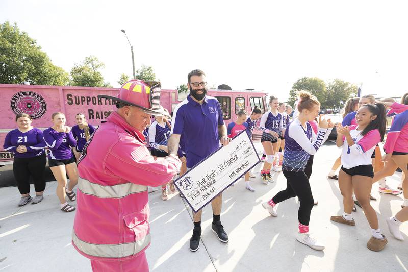 Pink Heals Sauk Valley president Brian Tribley (left) accepts a check from Dixon High School volleyball coach Bunyan Cocar Thursday, Oct. 2, 2025. In recognition of Breast Cancer Awareness Month, the teams raised money through donations and sales to donate $500 to Pink Heals and also a donation to a community member battling cancer.