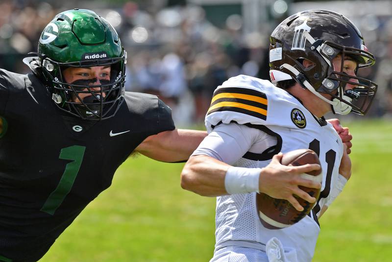 Joliet Catholic quarterback Lucas Simulick is stopped by Glenbard West’s Mason Flaherty during a game on September 6, 2025 at Glenbard West High School in Glen Ellyn.