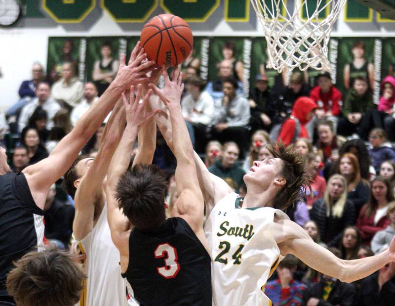 Crystal Lake South’s James Carlson, right, battles others under the hoop against Huntley in varsity boys basketball at Crystal Lake Friday night.