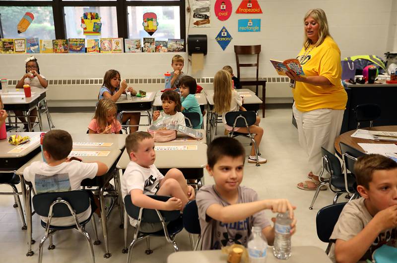 Second Grade teachers DeAnn Hopper reads a book as her students eat a snack during the first day of school on Tuesday, Aug. 12, 2025, at District 300's Westfield Community School in Algonquin.