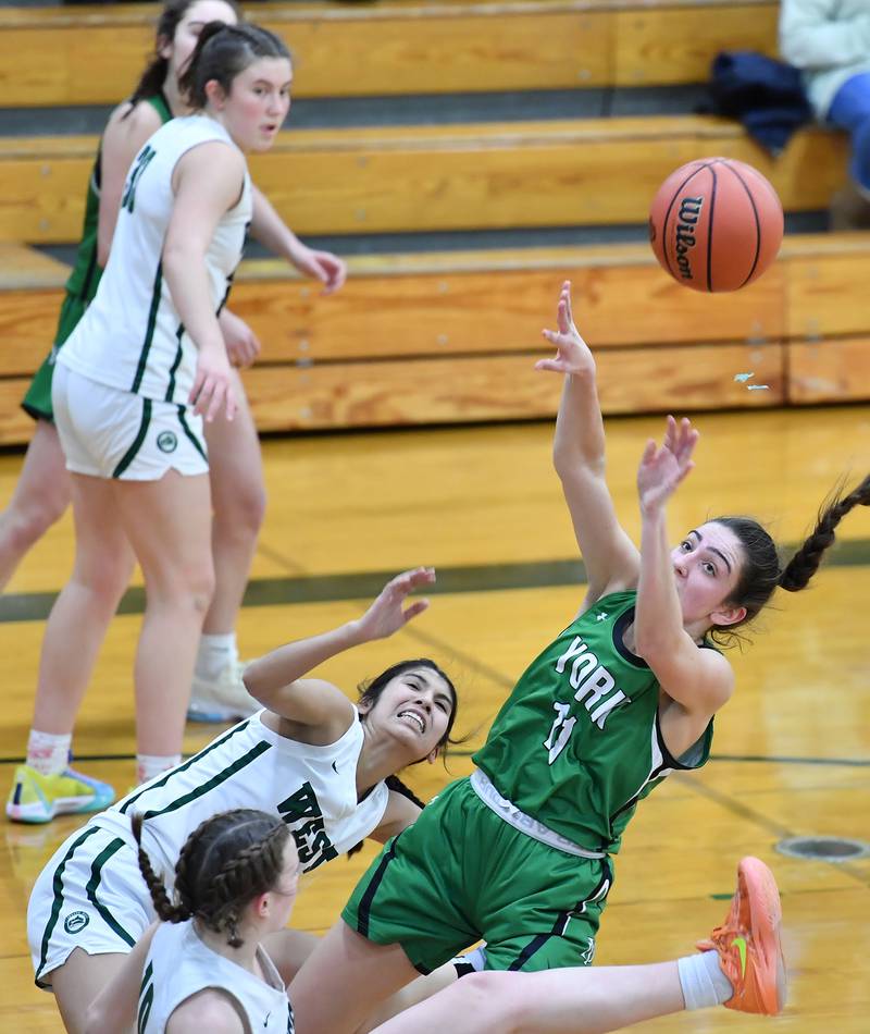 Mia Barton (11) tries to throw up a shot as she collides with Glenbard West's Sydney Nimsakont and Julia Benjamin (bottom) during a game on Jan. 22, 2024 at Glenbard West High School in Glen Ellyn.