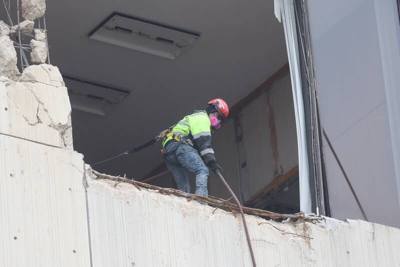 A worker pulls up a cable from a broken out window as crews begin demolition of the old Will County Courthouse on Thursday, Dec. 28th 2023 in Joliet.