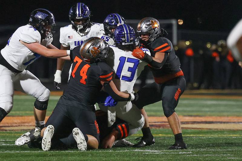 Minooka’s Hayden Kulousek (74) and Elliot Dahlberg bring down Lincoln-Way East’s Jonas Williams for the sack on Friday, Nov. 8, 2024 in Minooka.