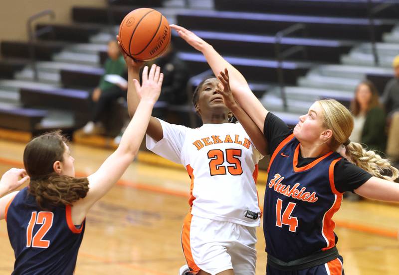 DeKalb’s Kezaria Mitchell looks to score between two Naperville North defenders Monday, Jan. 22, 2024, during their game at DeKalb High School.