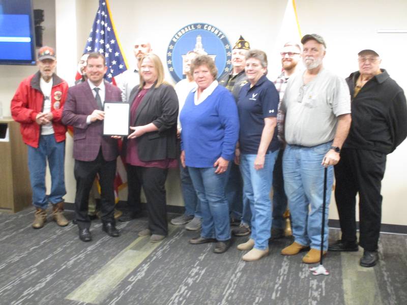 Kendall County Board Chairman Scott Gryder presents a proclamation honoring the Veterans Assistance Commission's 20th anniversary to Assistant Superintendent Karylin Clevenger and members of the organization on Nov. 15, 2022.