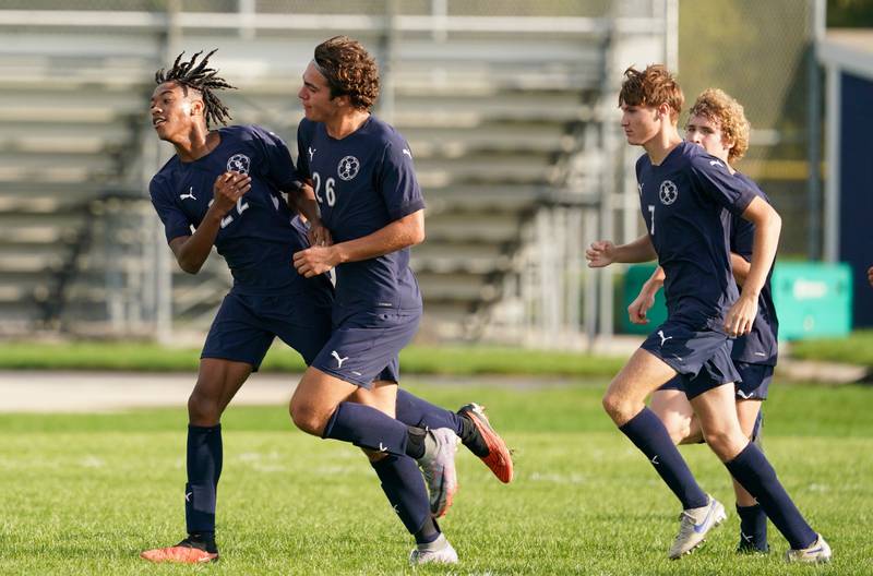 Oswego East's Marlin Hoffman (22) is greeted by Josh Lopez (26) after scoring a goal against Oswego during a soccer match at Oswego East High School on Tuesday, Sept. 26, 2023.