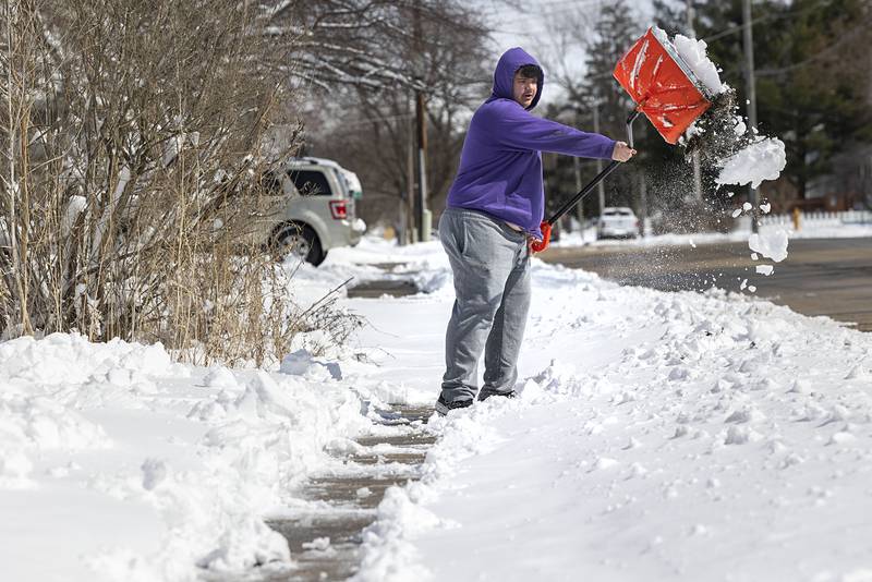 Brysen Hunt, 14, clears off a sidewalk Monday, March 16, 2026, in Dixon.