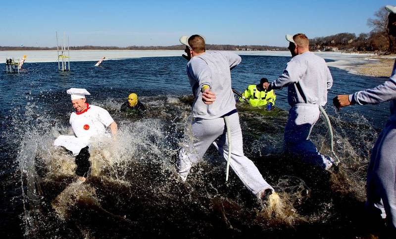 Costume-clad participants take a dip Sunday, Feb. 20, 2022, during the Polar Plunge in Fox Lake.