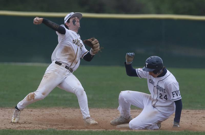 Jacobs' Gage Martin thries to turn a double play as Cary-Grove's Evan Frangiamore slides into second base during a Fox Valley Conference baseball game on Wednesday, April 17, 2024, at Cary-Grove High School. The game was stopped for darkness after the 9th inning with the score tied 6-6.