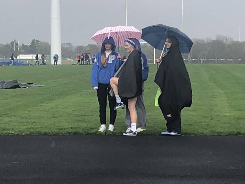 Princeton athletes take cover from the rain during Thursday's Three Rivers Track & Field Meet at Bureau Valley High School.