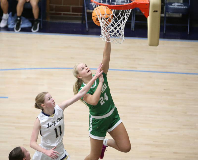Seneca's Piper Stenzel runs in all alone to score on a layup over Marquette's Keely Nelson on Thursday, Dec. 5, 2024 in Bader Gym at Marquette High School.