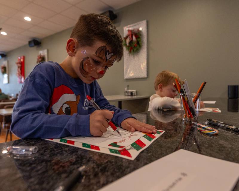Levi Pyszka writes letter to Santa at the annual Christmas in the Valley on Saturday, November 15, 2025 at the Tee Box in Spring Valley.
