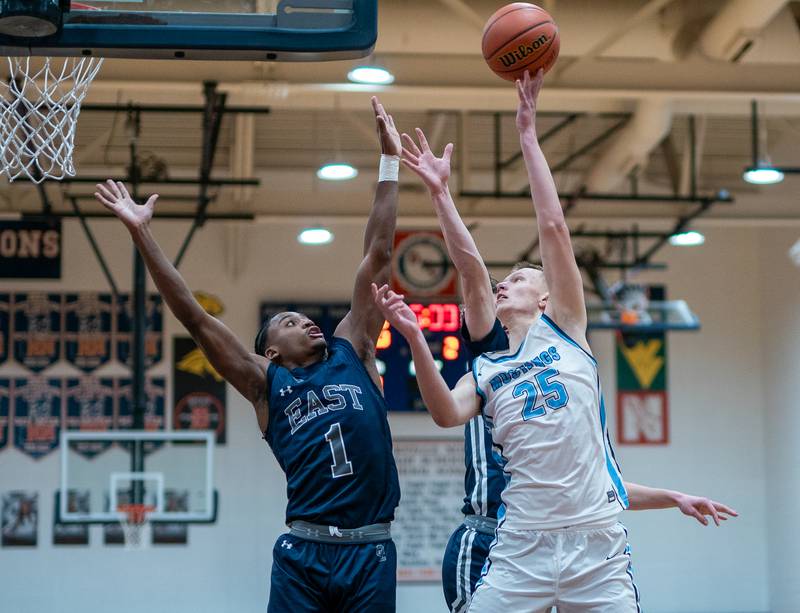 Downers Grove South's Daniel Sveiteris (25) plays the ball in the post against Oswego East's Andrew Wiggins (1) during the hoops for healing basketball tournament at Naperville North High School on Monday, Nov 21, 2022.