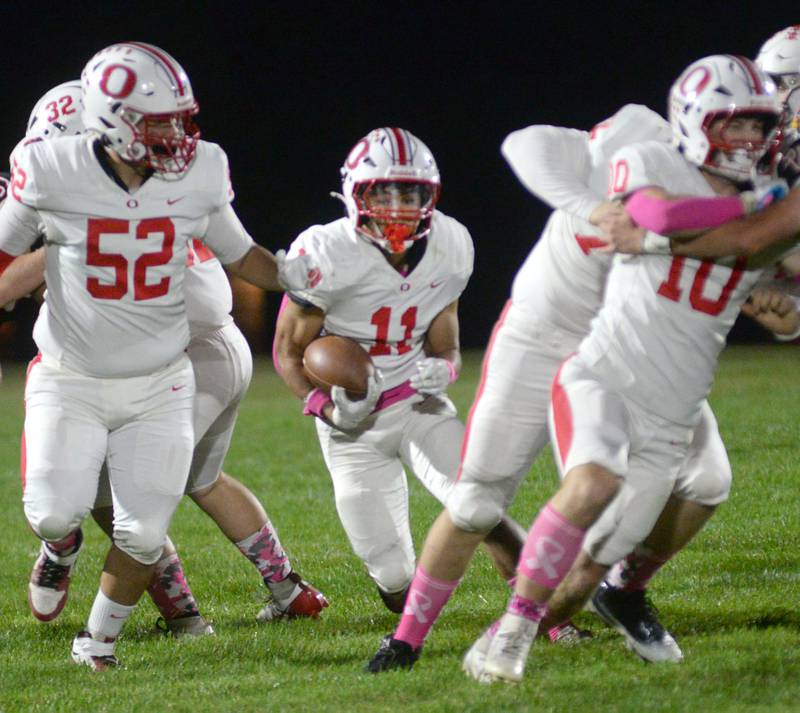 Oregon's  Jayden Berry (11) runs with the ball as Yovannie Carreno (52) and Keaton Salsbury (10) block against Stillman Valley on Friday, Oct. 10, 2025 in Stillman Valley.