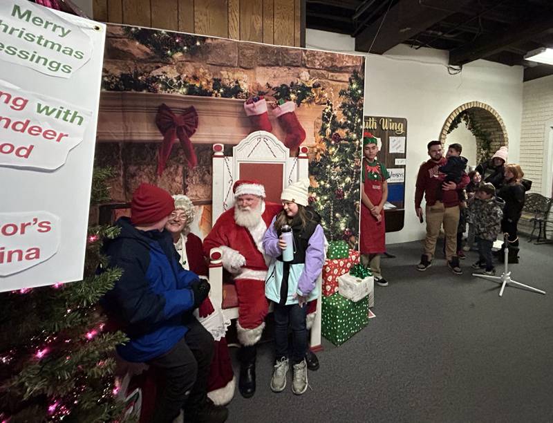 Santa and Mrs. Claus visit with kids at Conover Square Saturday, Nov. 30, 2024, during Oregon's Candlelight Walk. Shops were open in the historic building that once housed the Conover Piano Co., and piano players and other musicians provided music throughout the evening during the annual event.