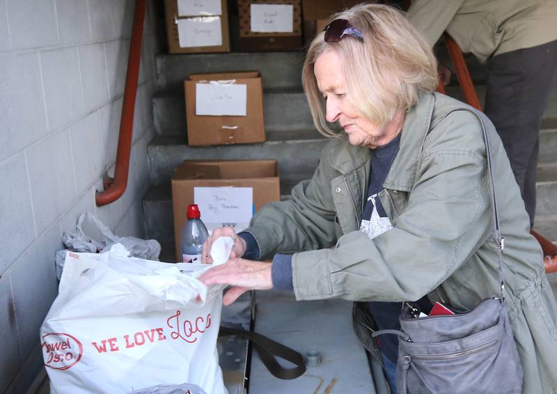 Kathy Cain, from Sycamore, takes items out of her bag for donation to the food drive Tuesday, Nov. 12, 2024, at the Stage Coach Theatre in Dekalb. The food collected will be assembled into dinner boxes to provide local families with a Thanksgiving meal.