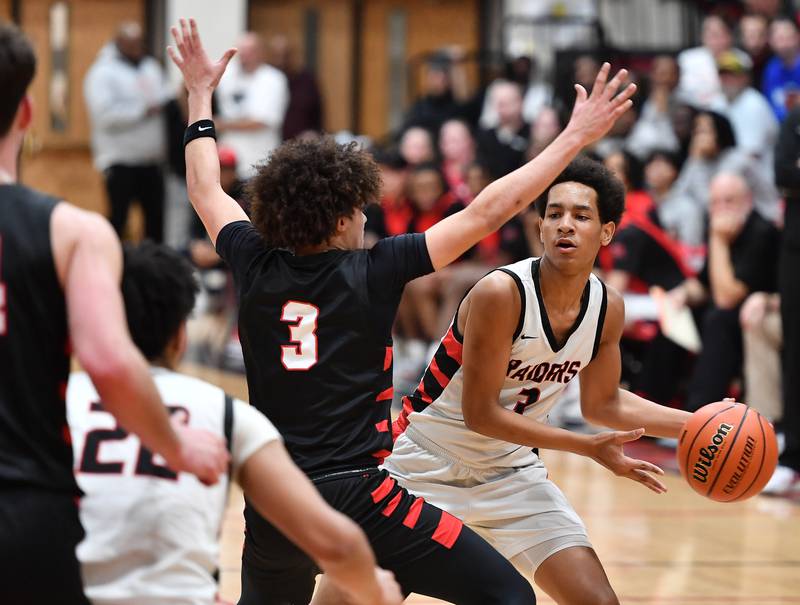 Bolingbrook's Davion Thompson (right) starts to pass around Benet's Jayden Wright during a Class 4A East Aurora Sectional semifinal game on Feb. 27, 2024 at East Aurora High School in Aurora.