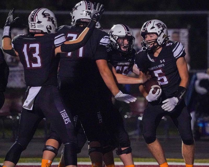 Plainfield North's Robert Tota (5) celebrates with his team after scoring a touchdown against Oswego during a football game at Plainfield North High School on Friday, Sept. 22, 2023.