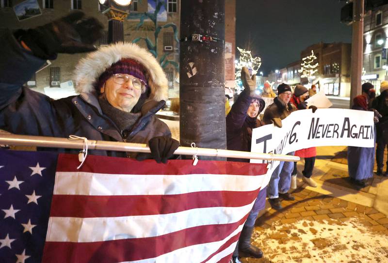 Tammy Johnston, (left) a member of Responsive Engagement Activating Civic Talent, waves at a passing car Friday, Jan. 6, 2023, during a Stand for Democracy demonstration at Memorial Park in downtown DeKalb. The second annual event was held to affirm the attendees commitment to American democracy.