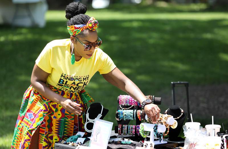 Paris Poole, from Paris' Crafts, gets her booth set up during the second annual Juneteenth celebration Sunday, June 19, 2022, at Hopkins Park in DeKalb.