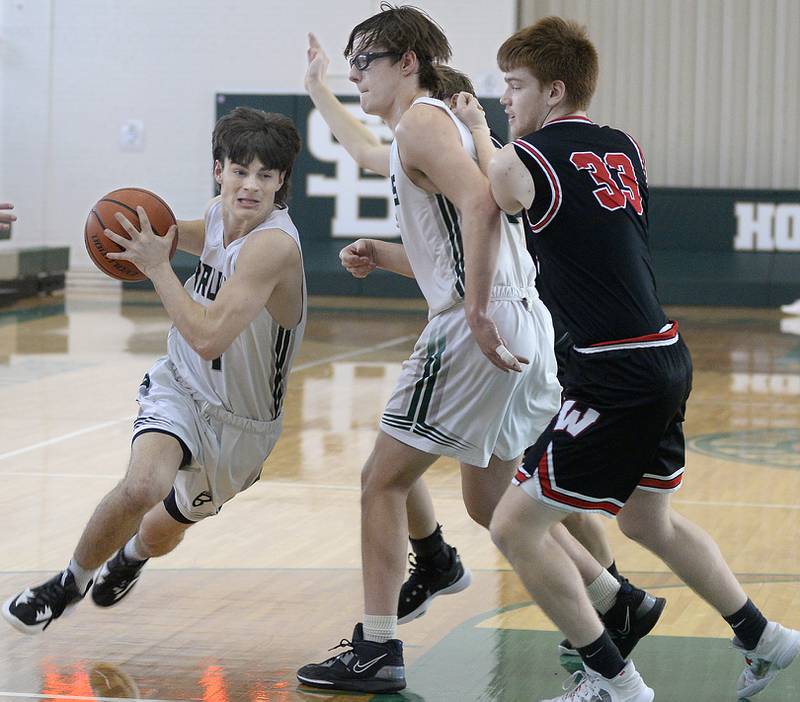 St Bede’s Callan Hueneburg drives to the basket as team mate Landon Jackson holds off Woodland’s Kenny Eutsey in the 1st period of the Class 1A Regional game on Saturday, Feb. 18, 2023 at St Bede.
