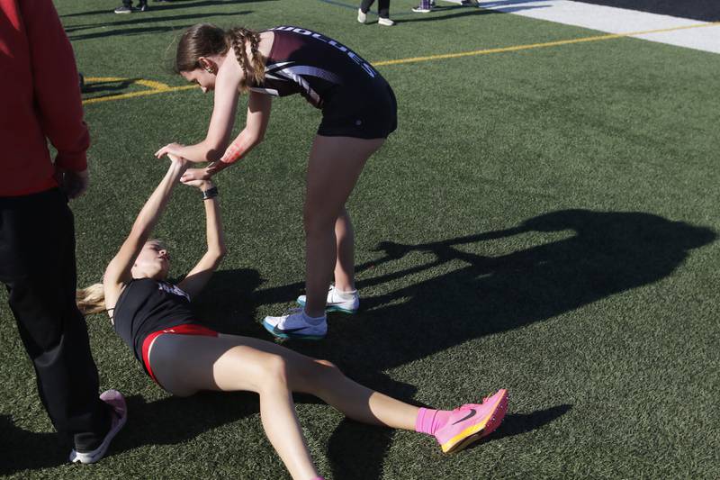 Prairie Ridge’s Emaline Foster (right) “high fives” Huntley’s Cori Kilvinger after the finish first and second in the 3200 meter run on Thursday, May 8, 2025, during the Fox Valley Conference Girls Track and Field Meet at Huntley High School.
