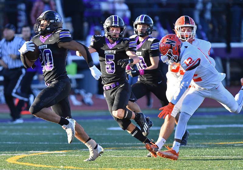 Downers Grove North's Noah Battle (20) returns a kickoff 85 yards for a touchdown to start the second half of an IHSA Class 7A semifinal game against Normal Community on Nov. 18, 2023 at Downers Grove North High School in Downers Grove .