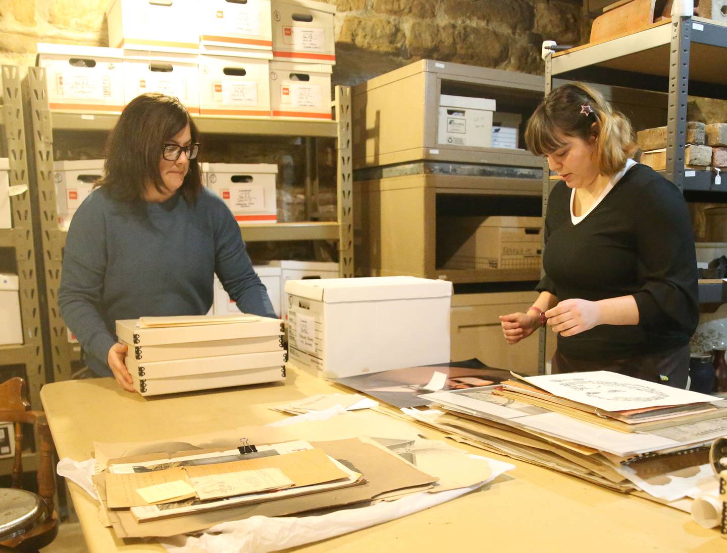 Amanda Carter (left), museum director, and Riley Dirks, collections manager, sort through Native American artifacts Monday, Jan. 29, 2024, in the storage area at the La Salle County Historical Society in Utica. New federal rules mean big work for the little museum in Utica: Carter and Dirks need to contact Native tribes for permission to display the many artifacts at the museum.