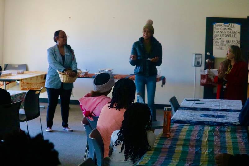 Shawnda Harris (center) is seen Nov. 15, 2025, speaking before fellow University Village residents on hand for a community meeting in DeKalb put on by DeKalb County Board members Rukisha Crawford (left) and Meryl Domina.