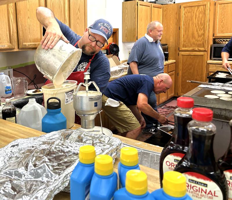 Mt. Morris Firefighter Rick Hough preps pancake batter in the kitchen with fellow firefighters and volunteers on Friday morning, July 4, 2025 cooking breakfast at the fire station.