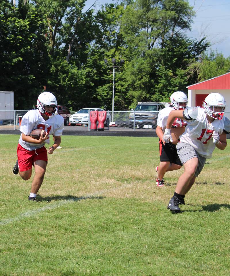 Jerrad Clark (21) returns an interception, following lead blocker Aiden Ferris (17), Wednesday, July 16, 2025, during Streator High football practice at Doug Dieken Stadium in Streator.