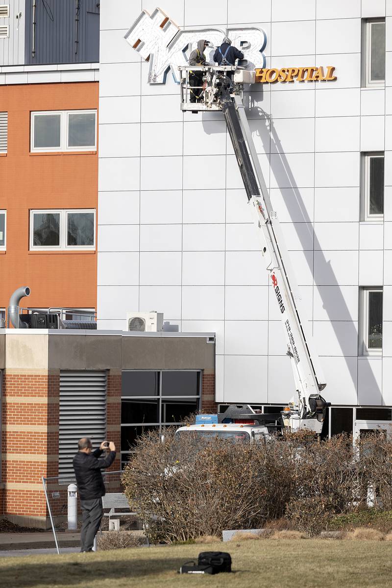 OSF Media Relations Coordinator Paul Arco snaps some video Friday, Dec. 13, 2024, as signage of KSB Hospital is removed. New signs for OSF Saint Katharine Medical Center will be put up at a later date.