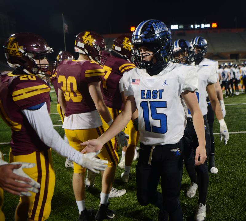 Lincoln-Way East quarterback Braden Tischer shakes hands with Loyola Academy players following the Griffins’ 13-3 loss during the Class 8A football state title game at Memorial Stadium in Champaign on Saturday, Nov. 26, 2022.