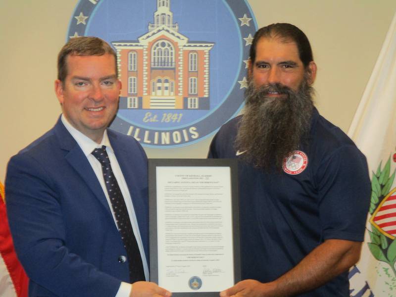 Oswego Paralympian Joe Berenyi, right, was honored for his achievements by the Kendall County Board on Aug. 2, 2022. Berenyi is shown here with board Chairman Scott Gryder. (Mark Foster -- mfoster@shawmedia.com)
