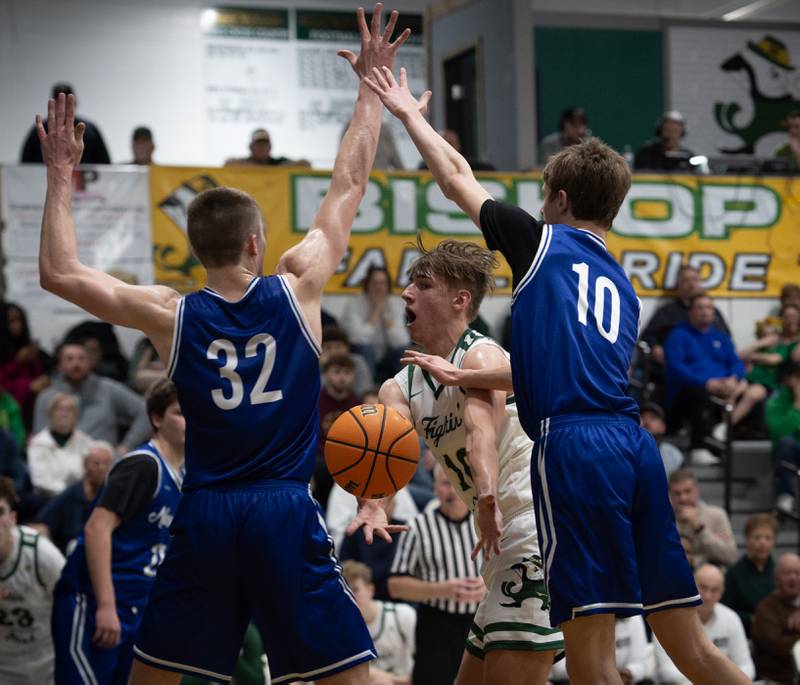 Bishop McNamara's Coen Demack, center, passes the ball as he makes a drive toward the net while Newark's Cody Kulbartz, left, and Dylan Kulbartz, right, guard in a game on Friday, Feb. 20, 2026.
