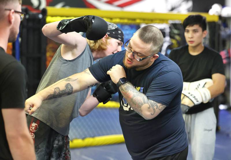 Joe Judkins, (right) head coach at Evolve MMA and Powerlifting, shows some moves to Chase Trautvetter, 16, from Sycamore, during a class Thursday, Nov. 9, 2023, at the facility in DeKalb.