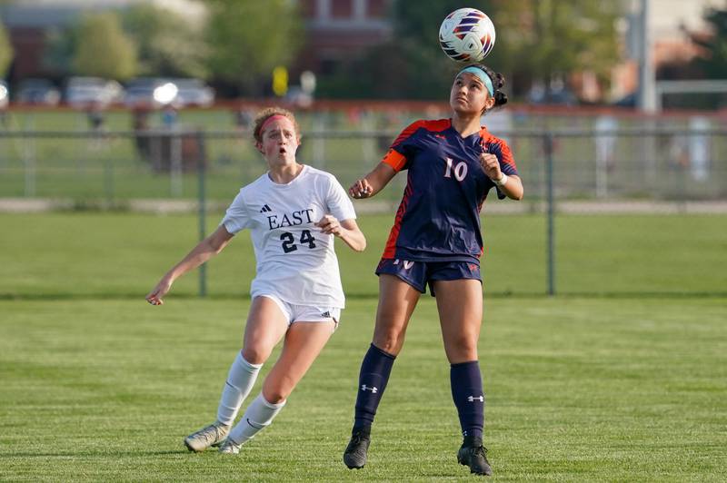 Oswego’s Natasha Lopez (10) heads the ball against Oswego East's Addison Olson (24) during a soccer match at Oswego High School on Tuesday, April 29, 2025.