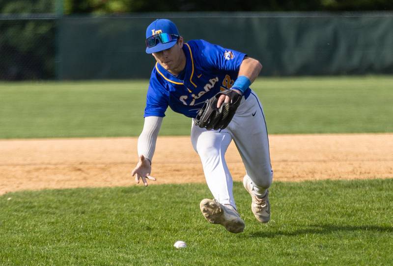 Lyon’s Township third baseman Lou Ratcliffe fields a bunted ball during a game against Downers Grove North in Downers Grove on Monday, May 12, 2025.