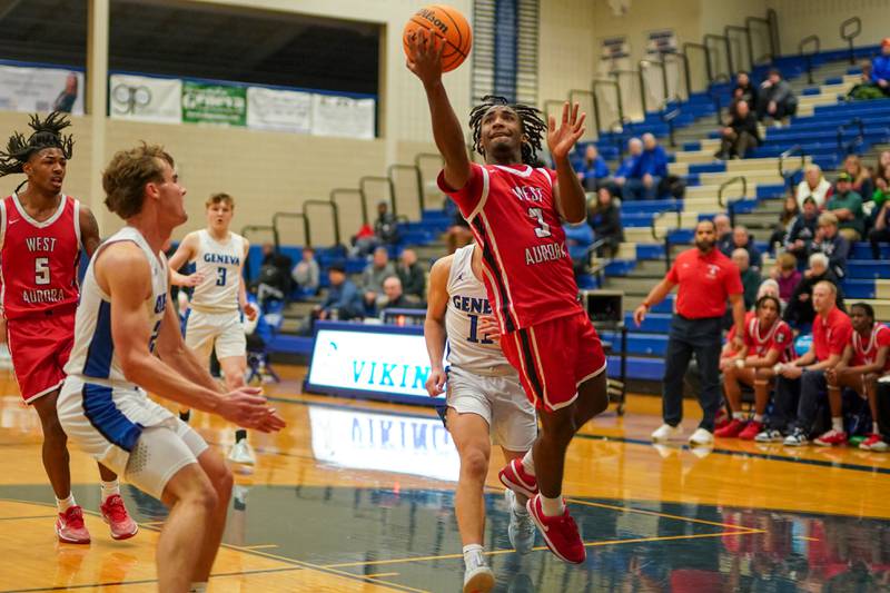 West Aurora's Jaden Edwards (3) drives to the hoop against Geneva’s Nelson J Wendell (11) during a MLK Day of Hoops basketball game at Geneva High School on Monday, Jan. 20, 2025.