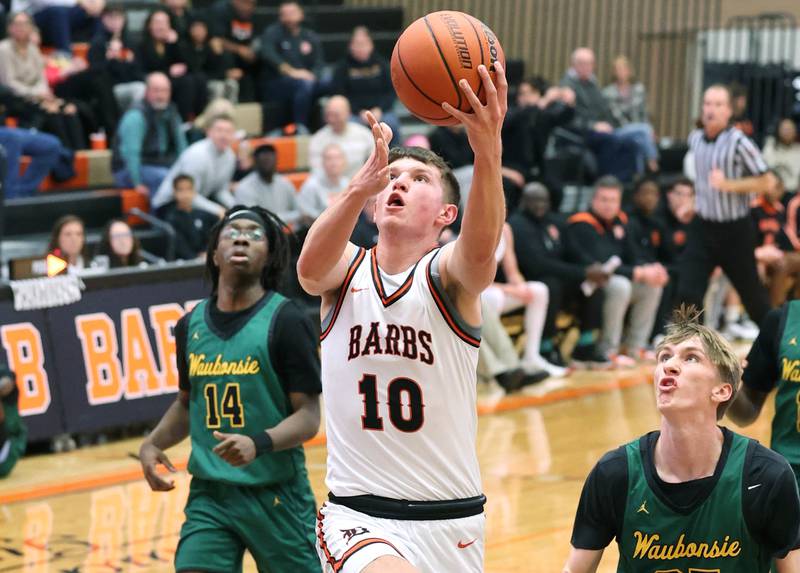 DeKalb’s Eric Rosenow drives through the Waubonsie Valley defense for a basket during their game Friday, Dec. 15, 2023, at DeKalb High School.